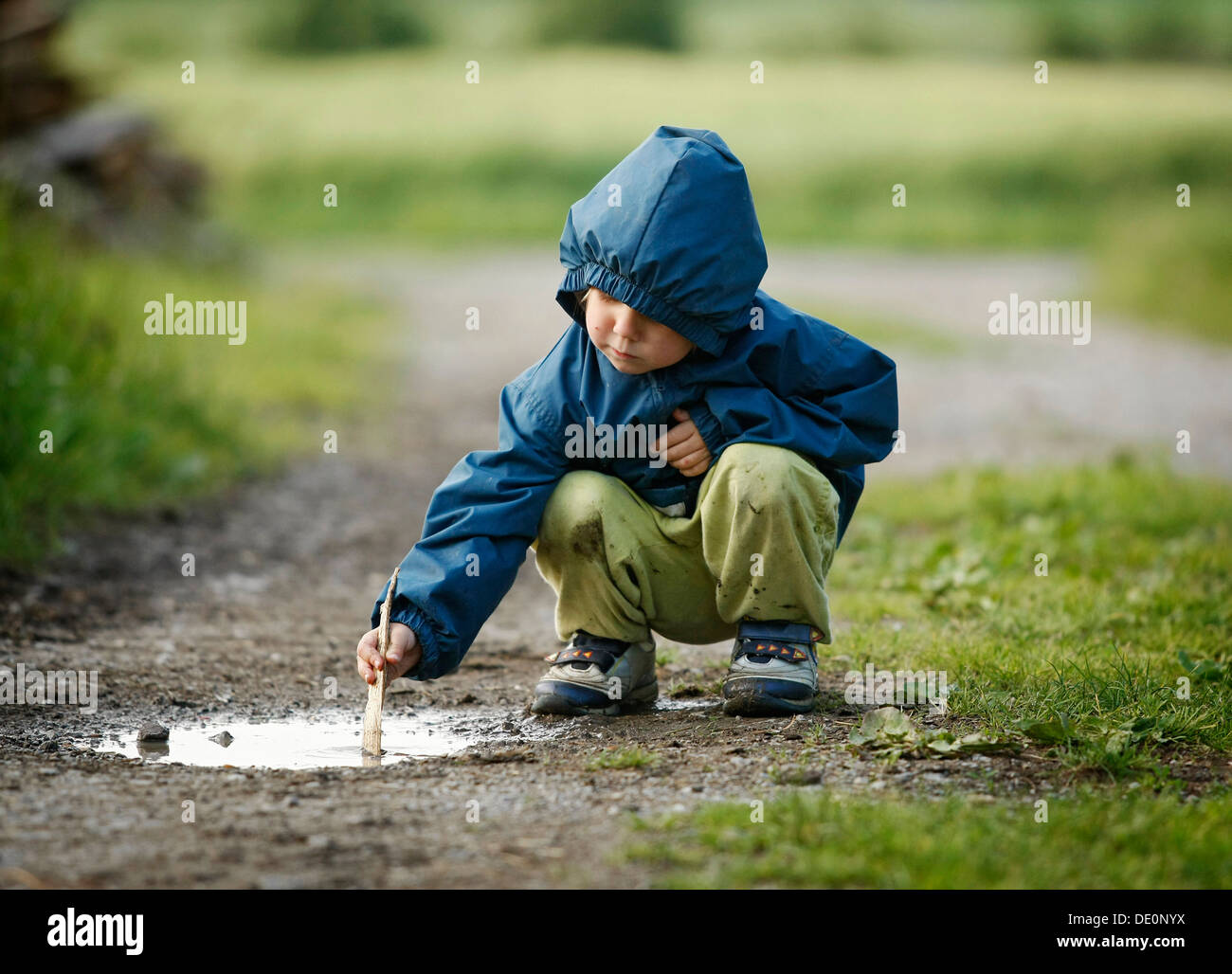 Girl, 4, playing in a puddle in the rain Stock Photo - Alamy