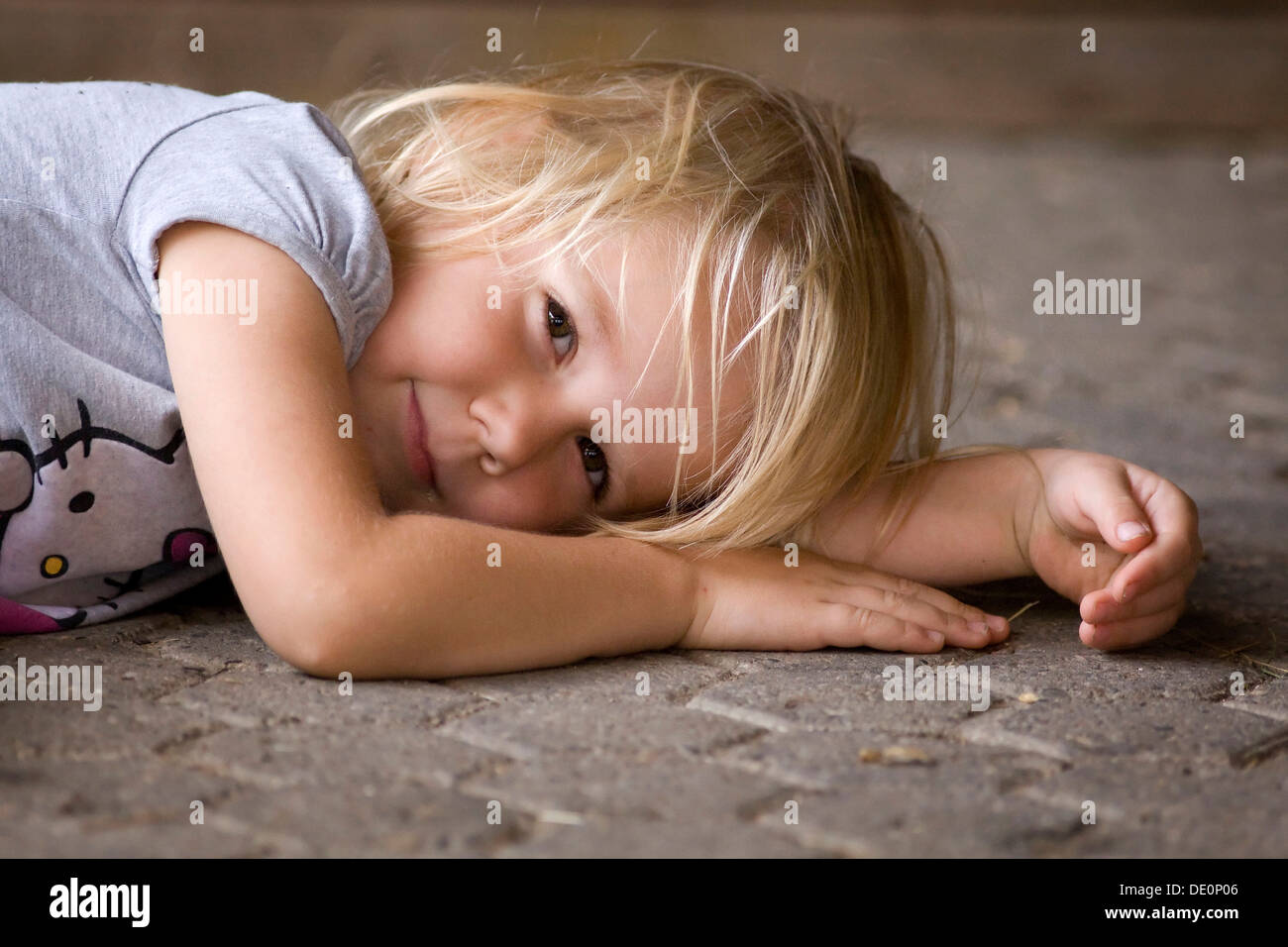 Smiling girl, 4, lying on the ground Stock Photo