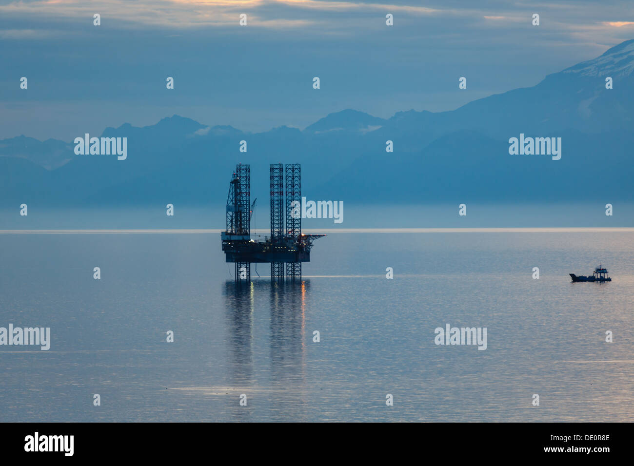 Oil and gas platform in the Cook Inlet Alaska with snow capped mountains in the background Stock Photo