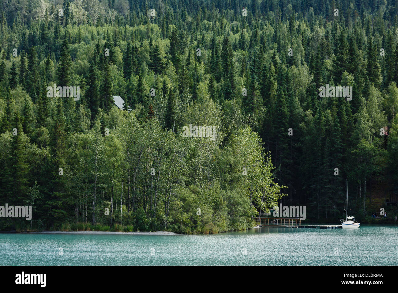 Sailboat moored on peaceful glacial lake in Alaska during summer Stock Photo