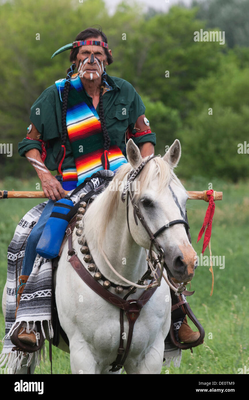 Warrior in Comanche clothing and war paint riding white horse Stock ...