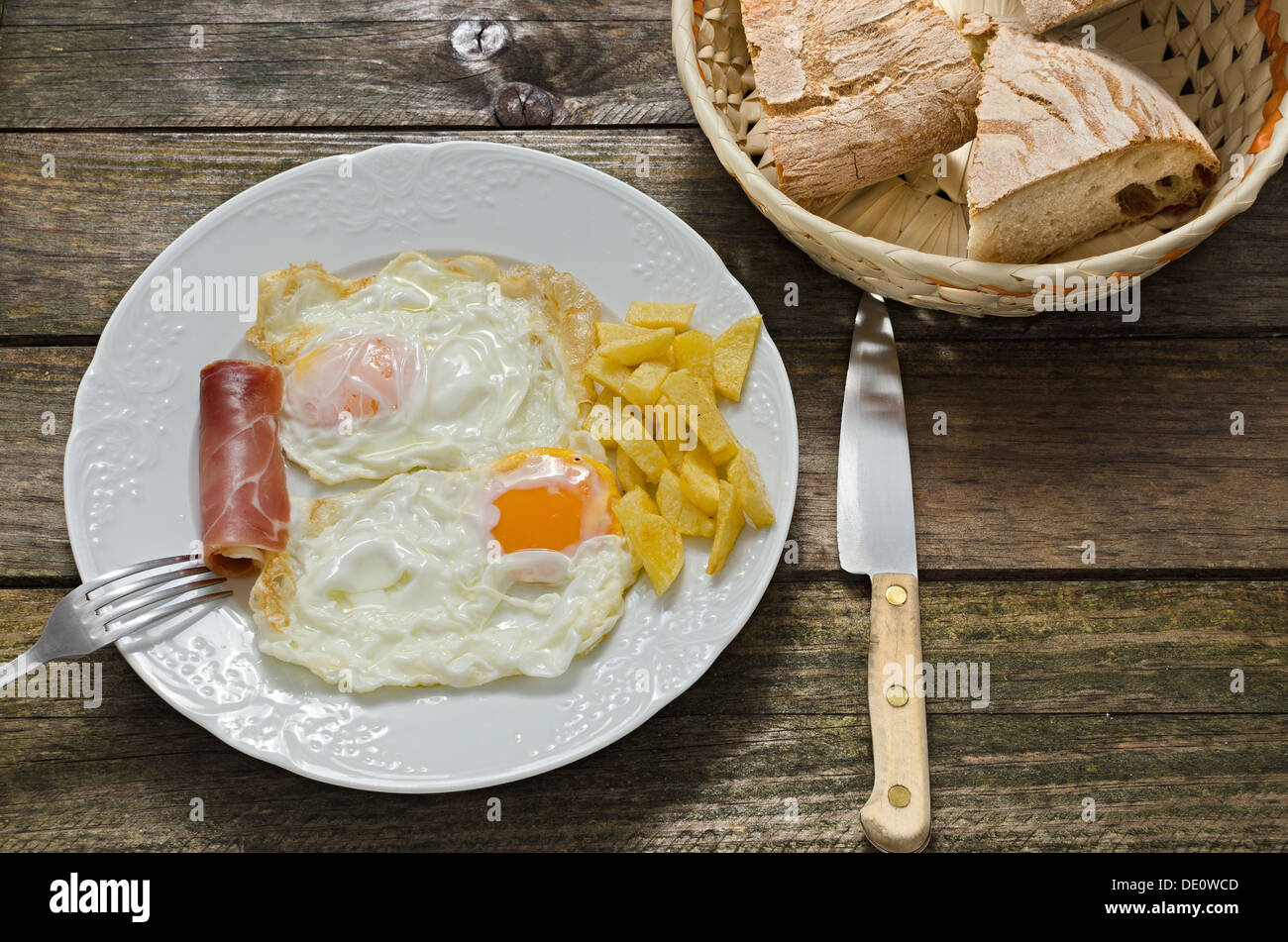 two fried eggs, fried potatoes and ham Stock Photo