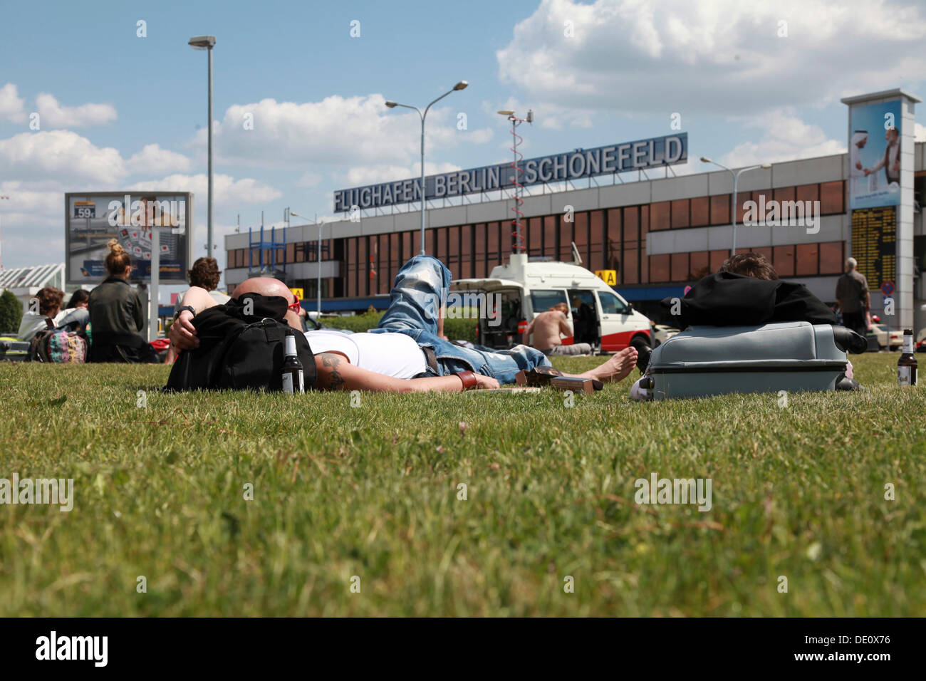 Passengers waiting for their flights on the lawn in front of the Berlin-Schoenefeld airport terminal building Stock Photo