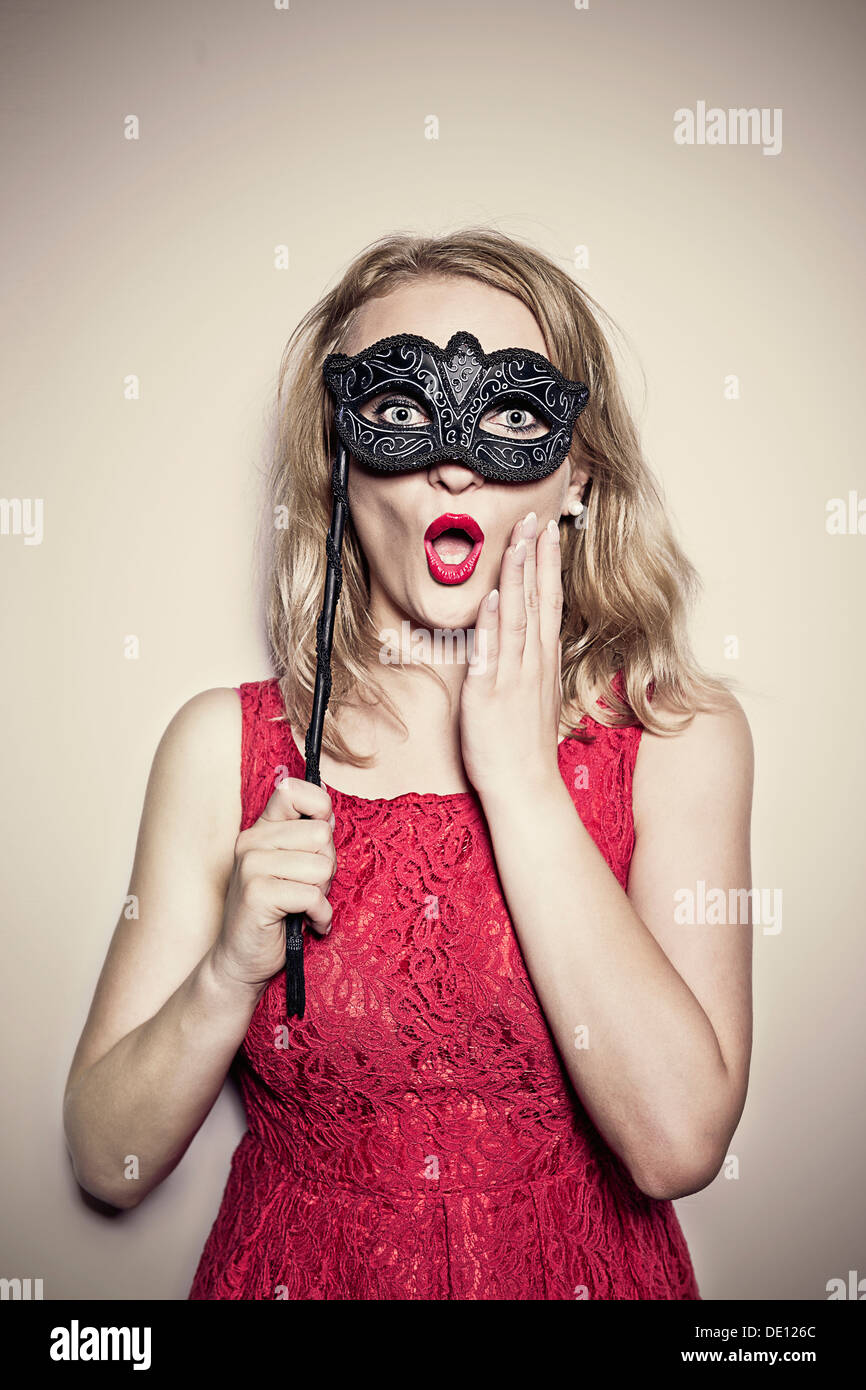 girl in a red dress with a carnival mask Stock Photo