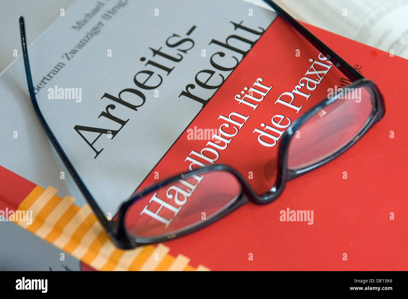 Glasses on a book, German for Employment law handbook Stock Photo