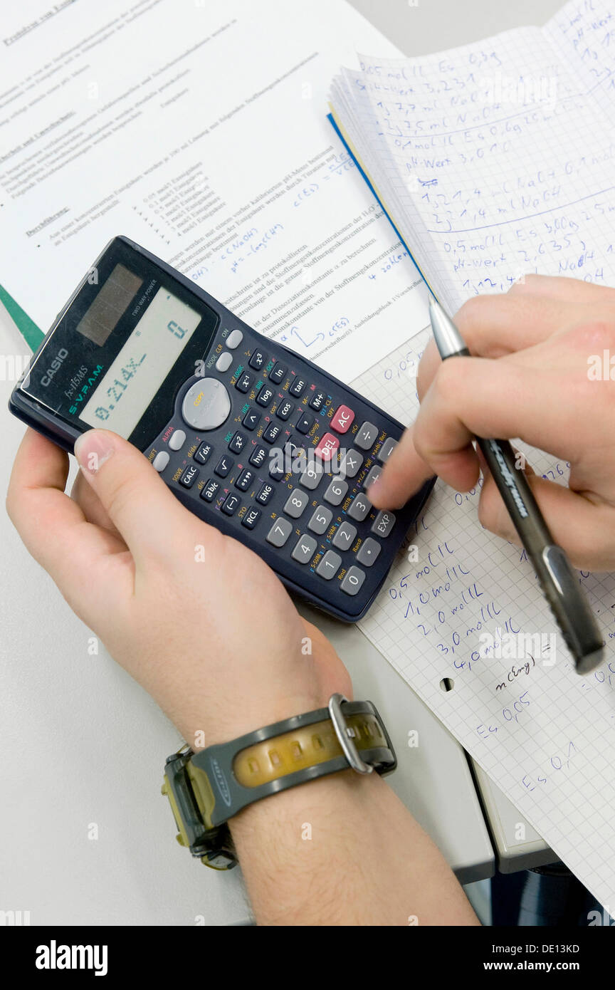 Written documentation and analysis with a calculator, first year apprentice, chemical laboratory worker, AlzChem Trostberg GmbH Stock Photo