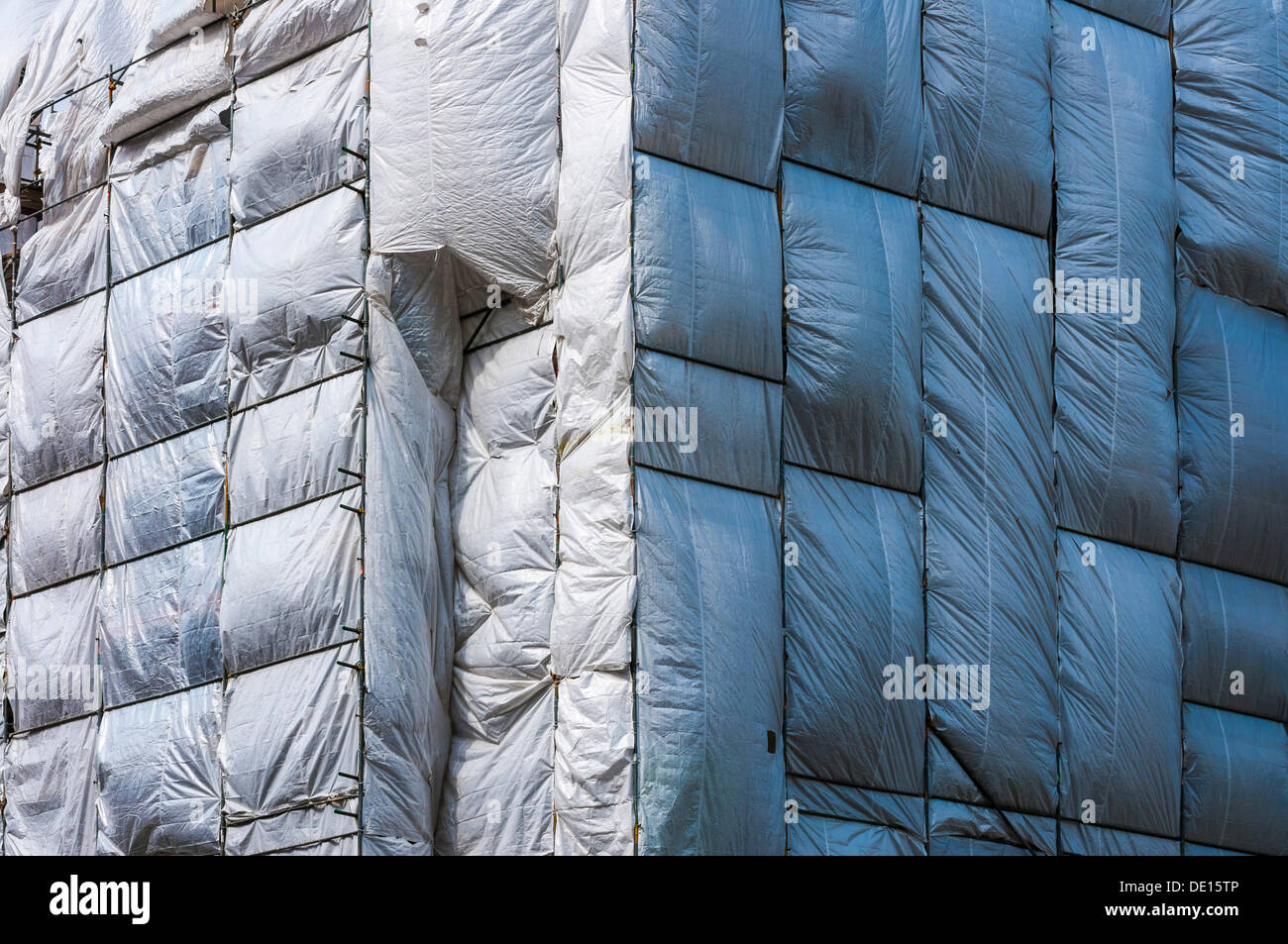 Scaffolding surrounded by a silver plastic tarp, protection from falling components, Frankfurt am Main, Hesse, Germany Stock Photo