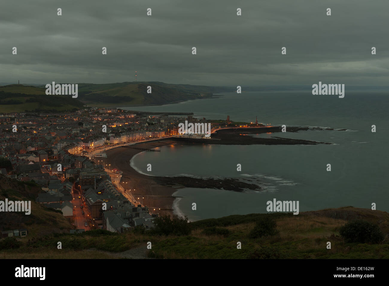Nighttime view of Aberystwyth bay with seaside light and calm sea at