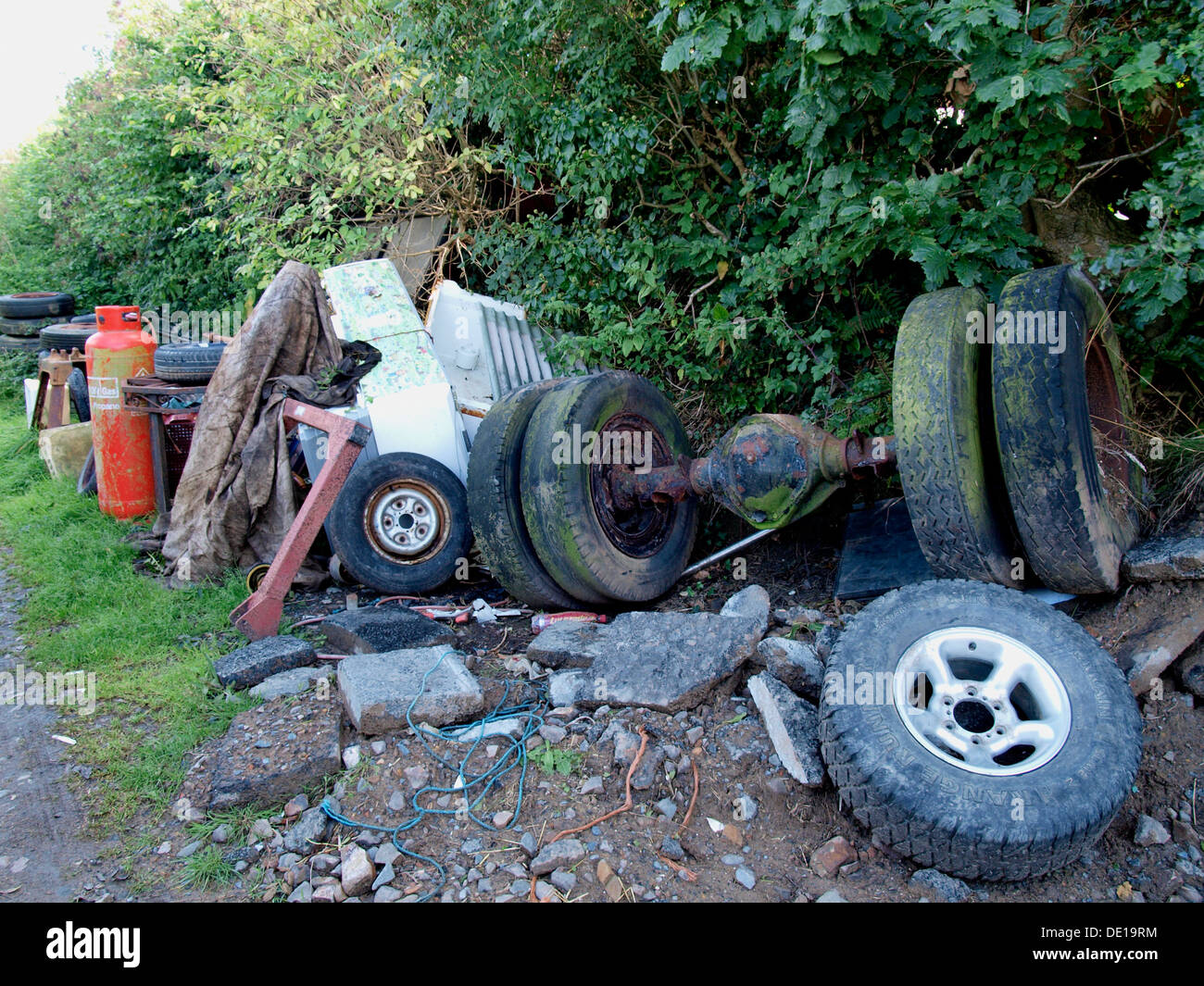 Old scrape tires and rubbish on the side of a farm track, Cornwall, UK 2013 Stock Photo