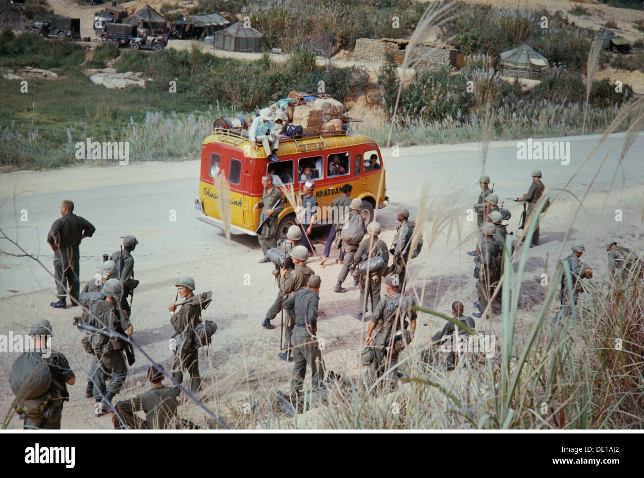 Vietnam War 1957 - 1975, American soldiers and Vietnamese minibus on a road near a bivouac, South Vietnam, 1965, camp, camps, tent, tents, transport, transportation, buses, busses, military, Armed Forces, army, armies, USA, United States of America, South-East Asia, South East Asia, Southeast Asia, Far East, Viet Nam conflict, Viet Nam, Vietnam, war, wars, conflict, conflicts, 1960s, 60s, 20th century, people, group, groups, soldiers, soldier, minibus, mini bus, road, roads, historic, historical, Additional-Rights-Clearences-Not Available Stock Photo