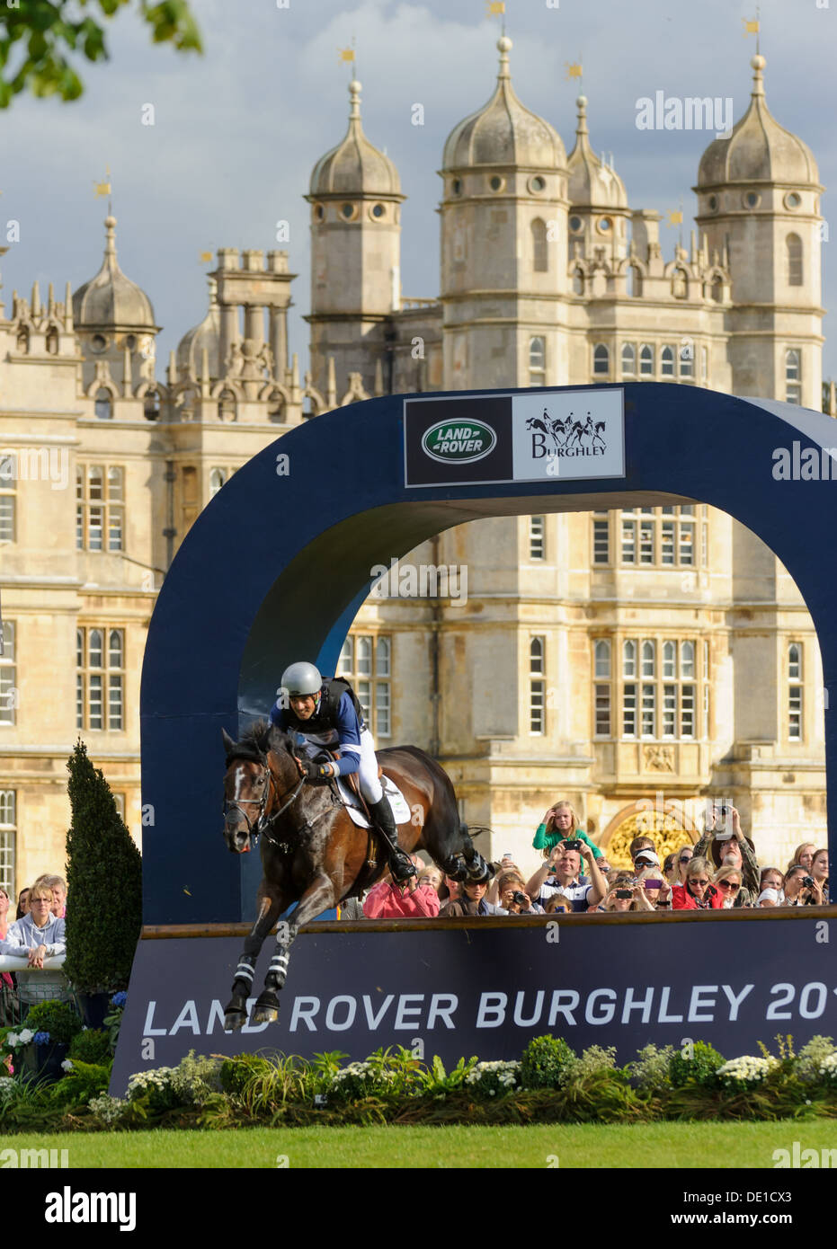 Jonathan Paget and CLIFTON LUSH jump the Olympic final fence during their cross country round, Burghley Horse Trials 2013. Stock Photo