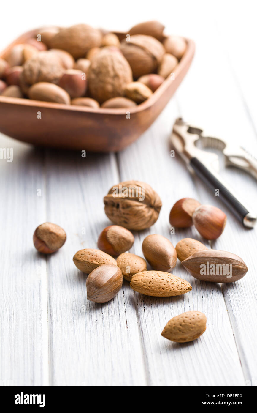 various unpeeled nuts on wooden table Stock Photo