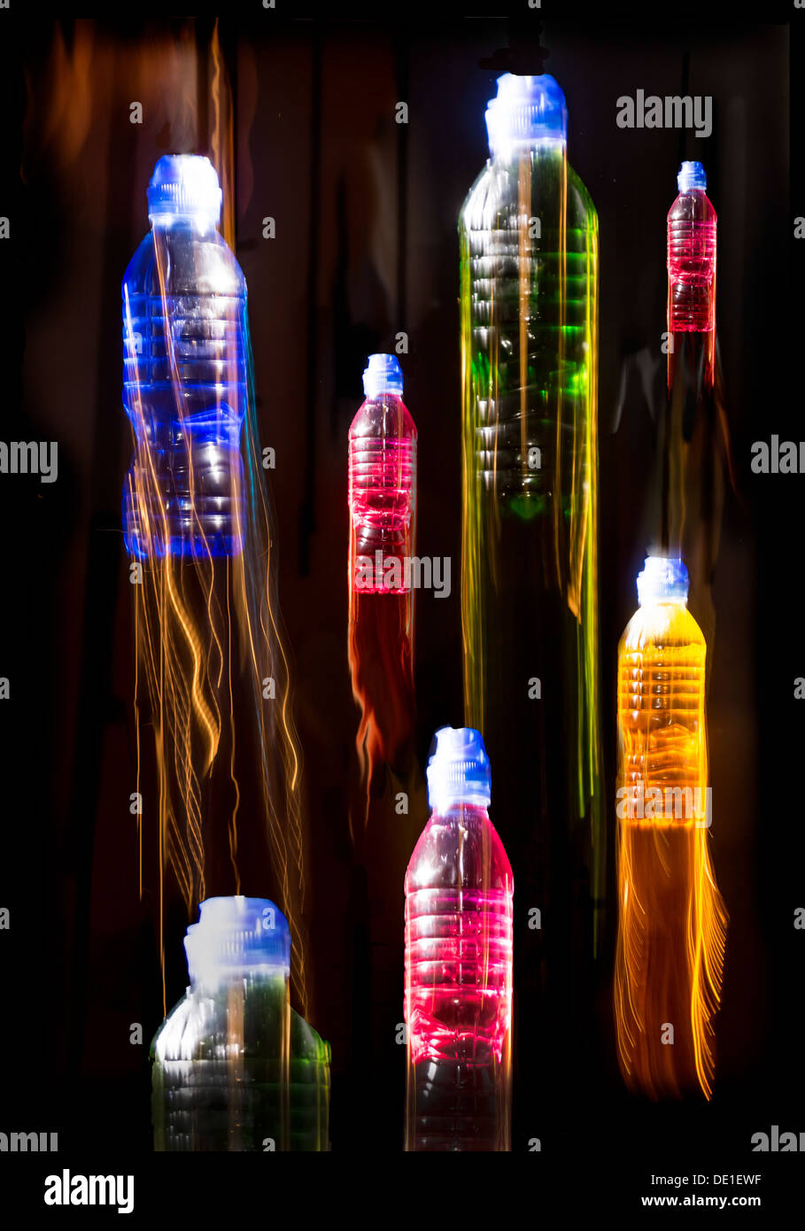 Swinging bottles creating coloured light trails Stock Photo