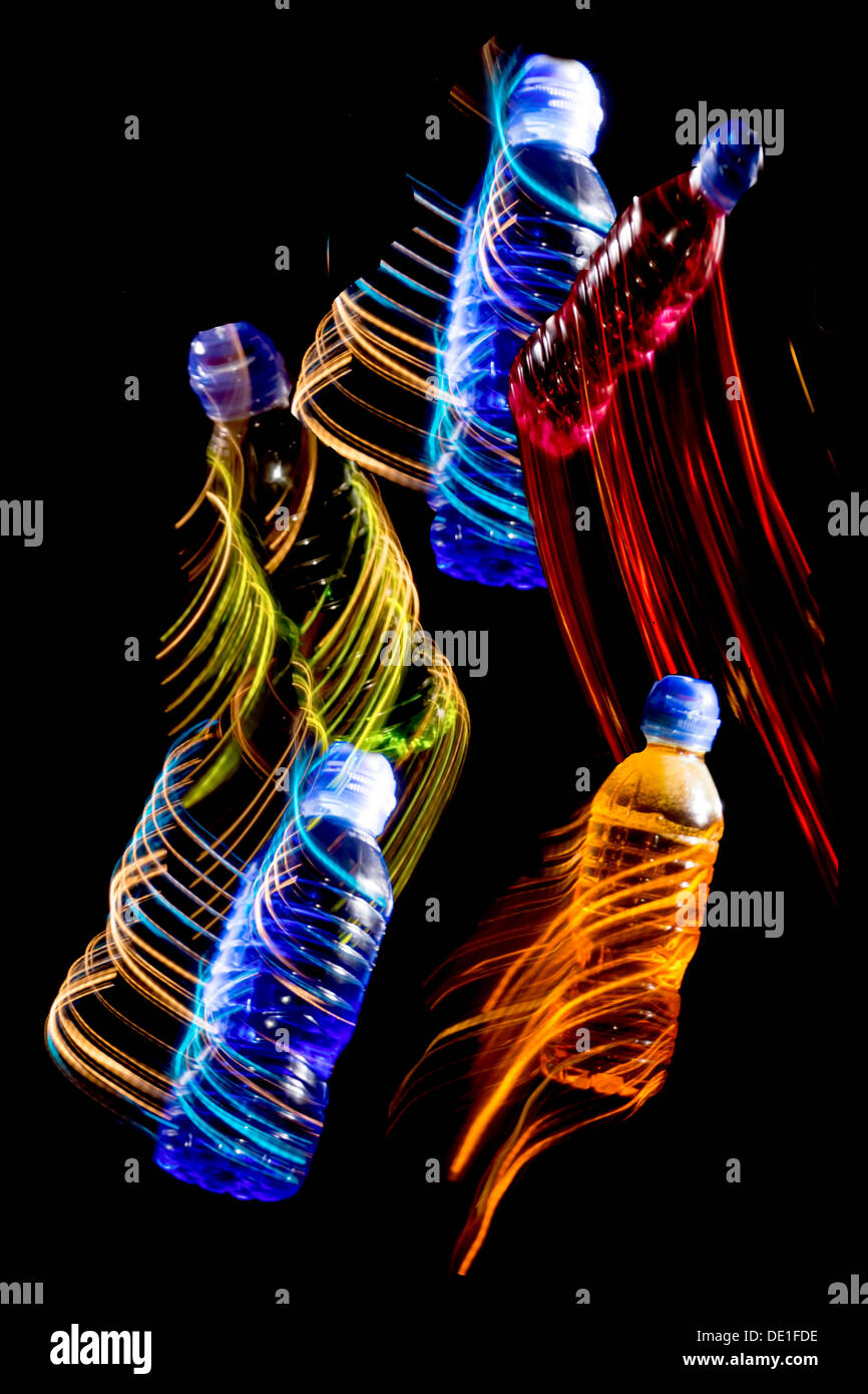 A fantasy of coloured bottles dancing against a black background Stock Photo