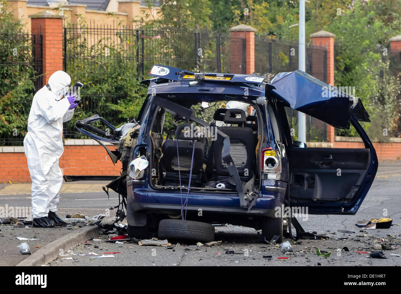 Belfast, Northern Ireland. 10th September 2013 - A PSNI forensics officer photographs the vehicle after army ATO carried out a controlled explosion. Credit:  Stephen Barnes/Alamy Live News Stock Photo