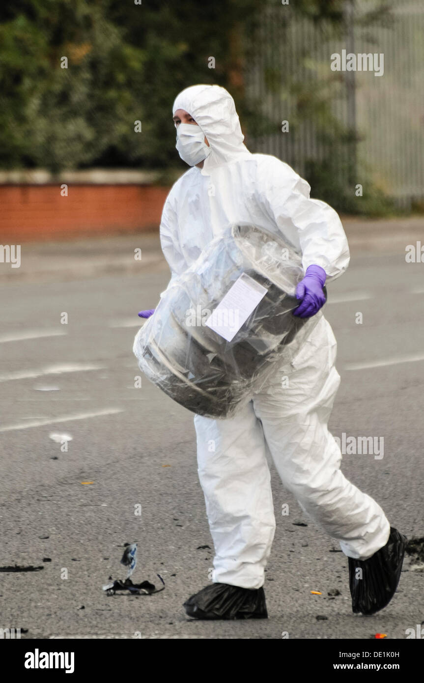 Belfast, Northern Ireland. 10th September 2013 - A PSNI forensics officer carries away the beer keg which was in the rear of an abandoned vehicle in a plastic bag. Credit:  Stephen Barnes/Alamy Live News Stock Photo