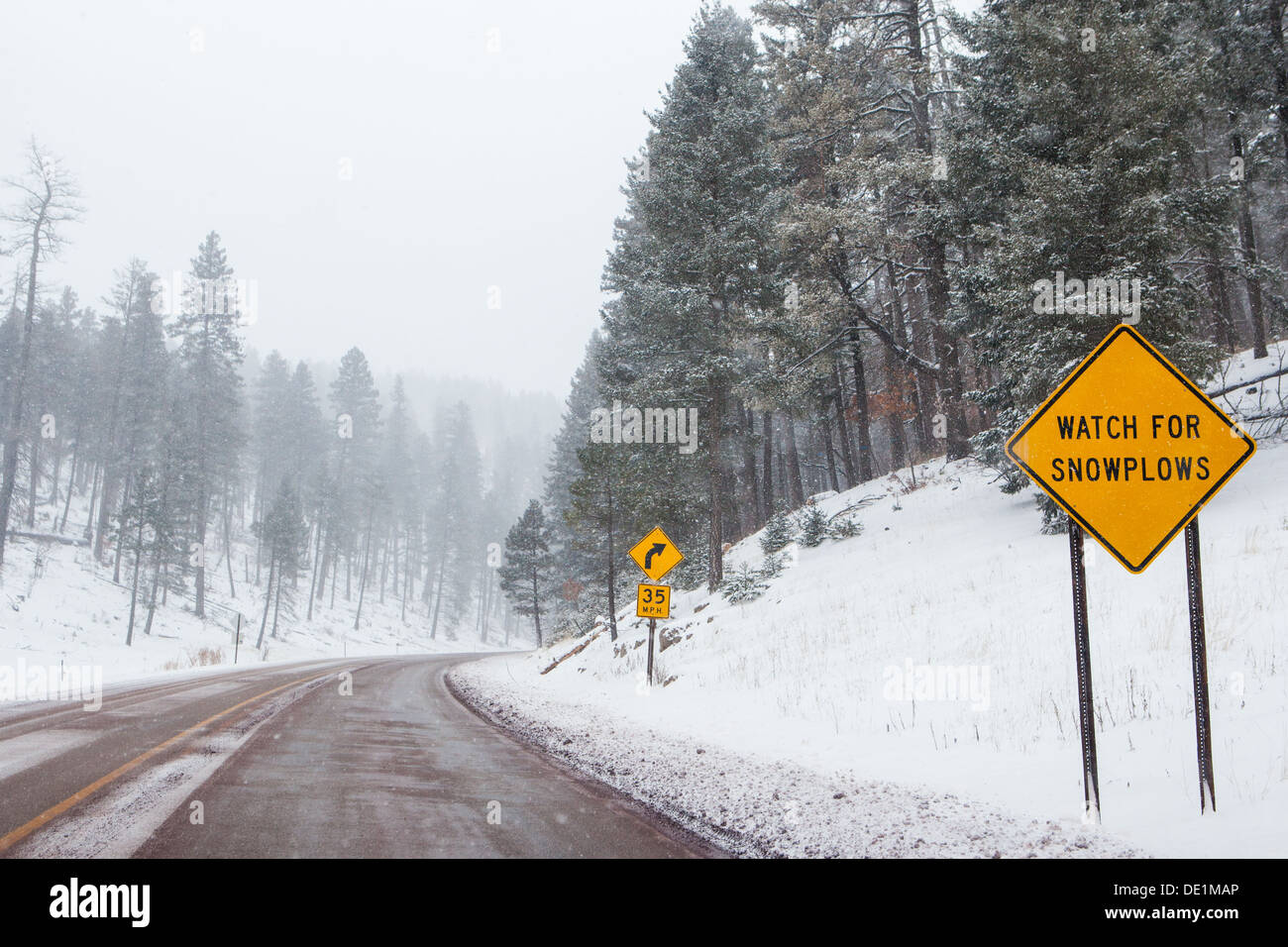 A snowy mountain road with warning signs in Cloudcroft, New Mexico