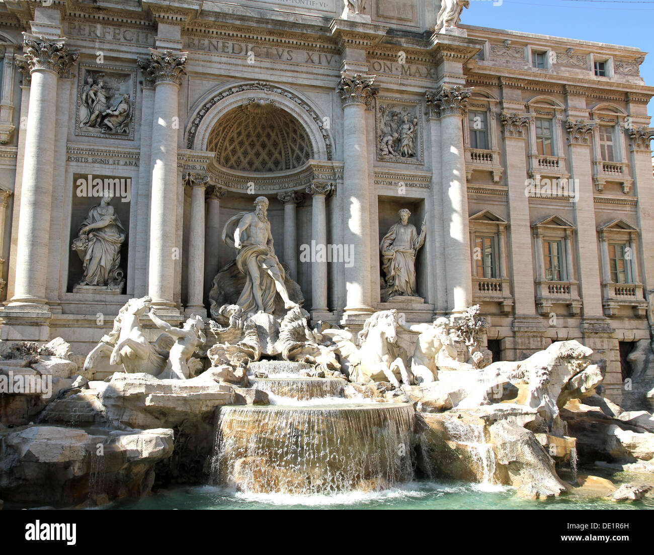 cool running water gushes from the trevi fountain in Rome with white marble statues Stock Photo
