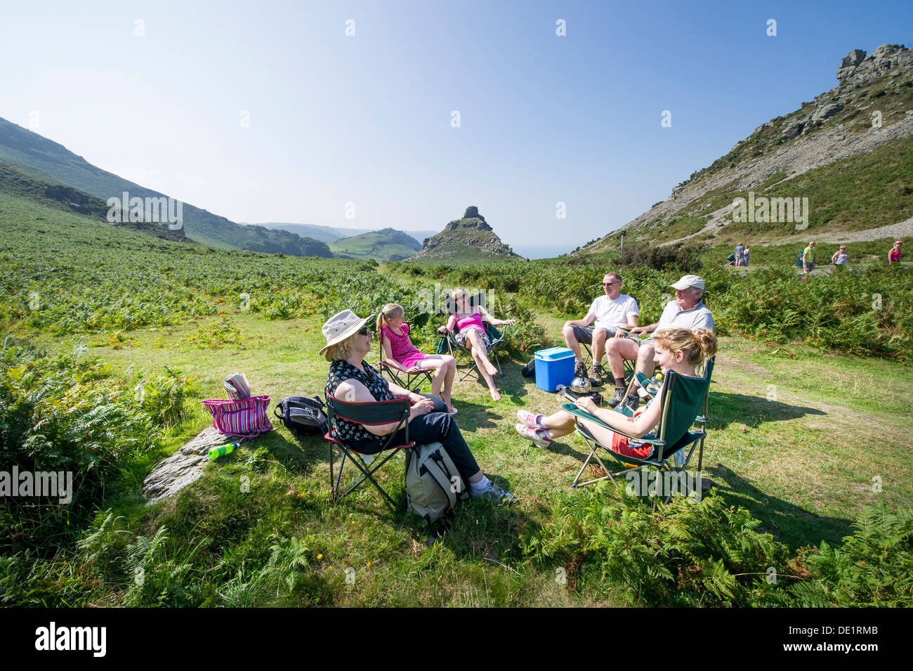 A family enjoy a picnic day out on holiday in the Valley Of Rocks, Lynton, Devon, UK Stock Photo