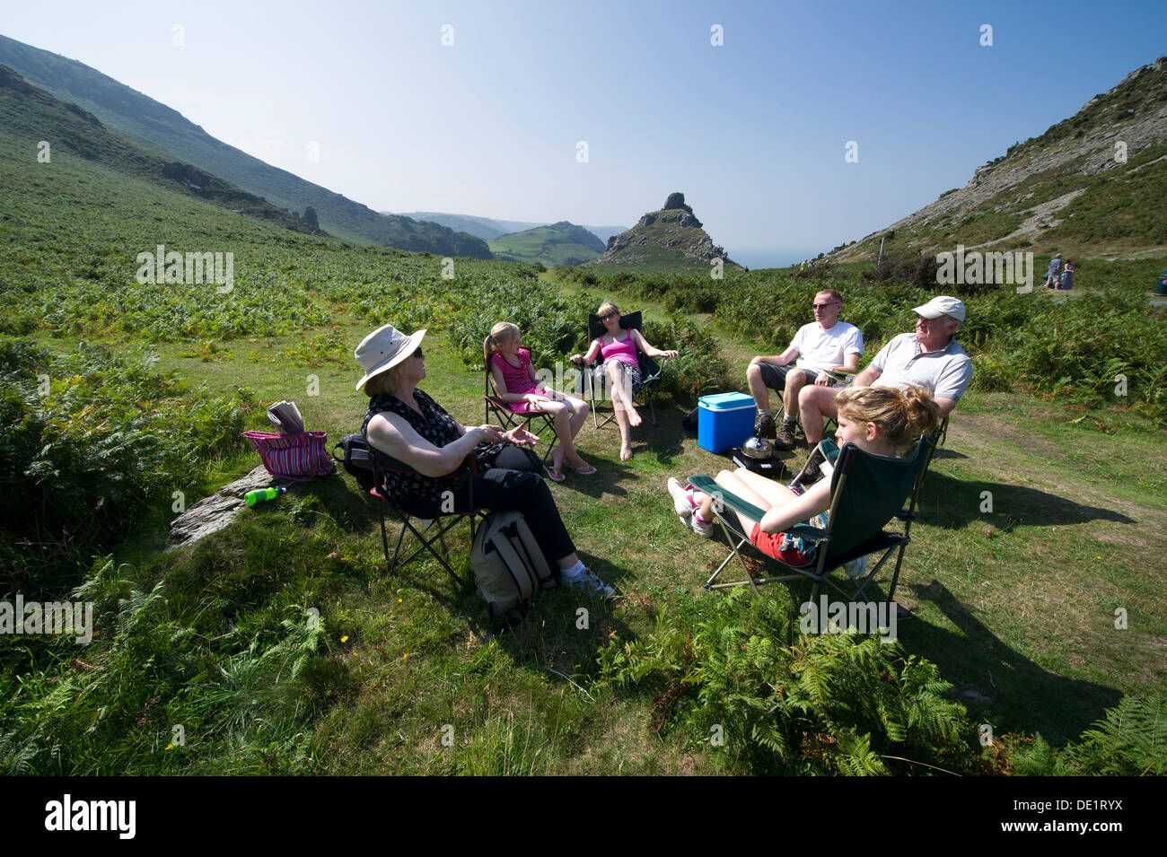A family enjoy a picnic day out on holiday in the Valley Of Rocks, Lynton, Devon, UK Stock Photo