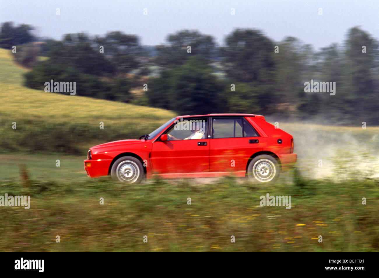 Lancia Delta Integrale HF Sports Car 4x4 4WD 1990s - driving through gravel side view in red Stock Photo