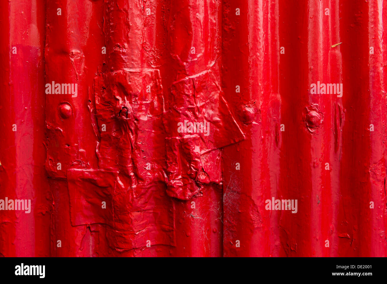 Corrugated iron, painted red, partially repaired Stock Photo