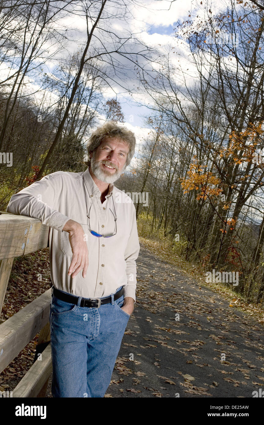 Man leaning on rail outdoors Stock Photo - Alamy