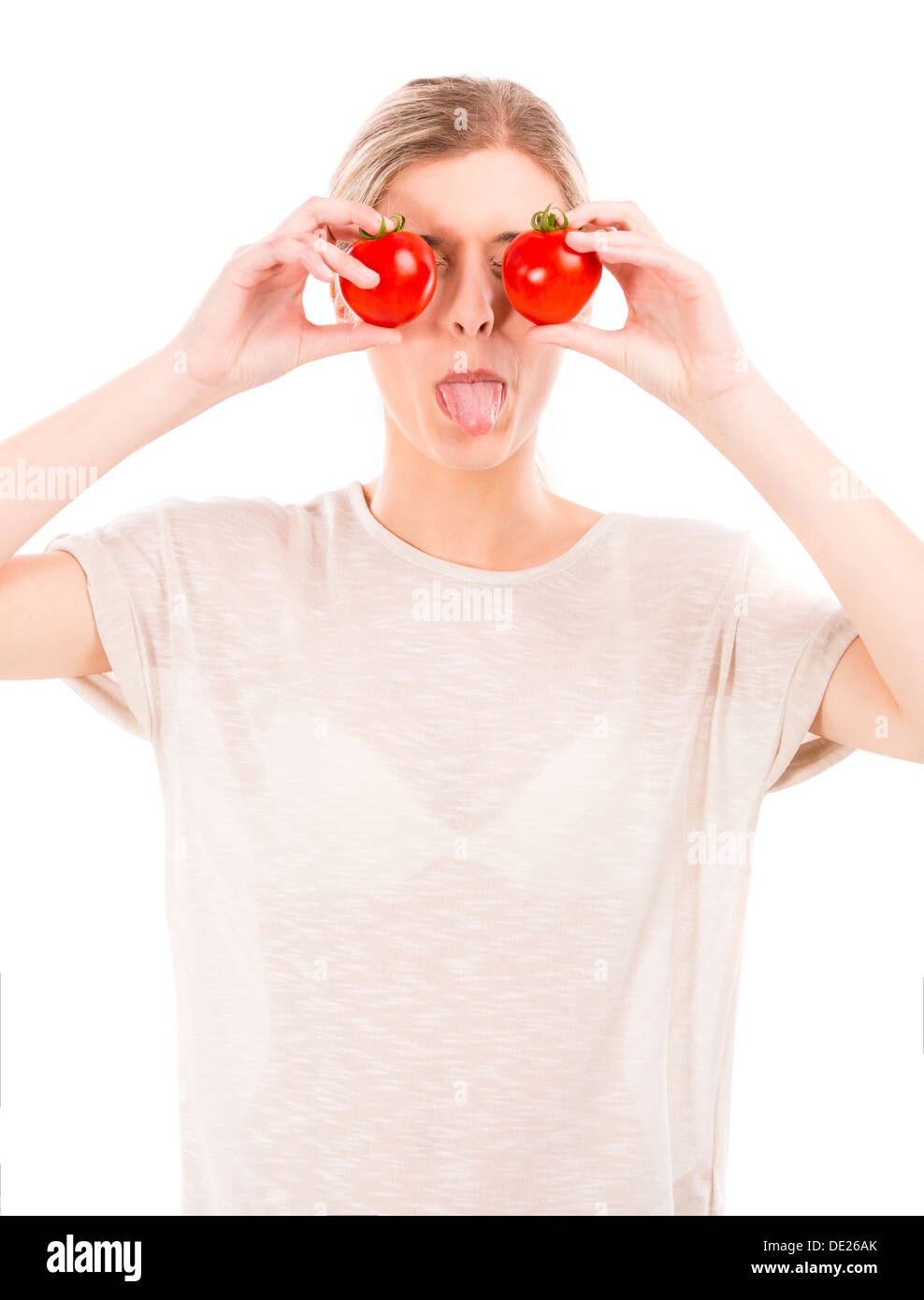Beautiful girl holding red tomatoes in front of the eyes and throwing ...