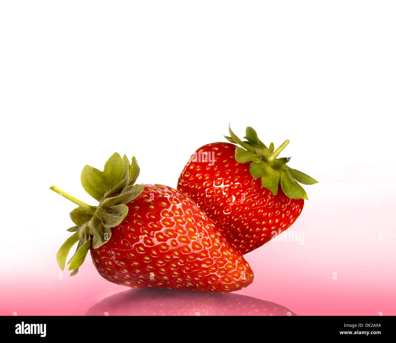 Two strawberries on pink, Bavaria, Germany Stock Photo