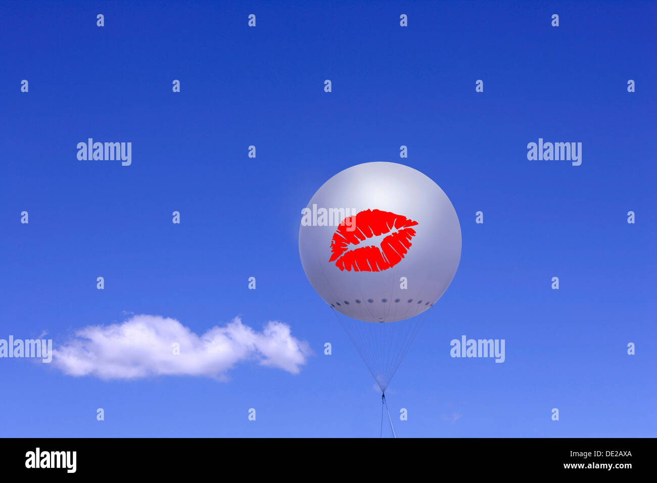 White balloon with printed red lips against a blue sky and a cloud, illustration, Germany Stock Photo
