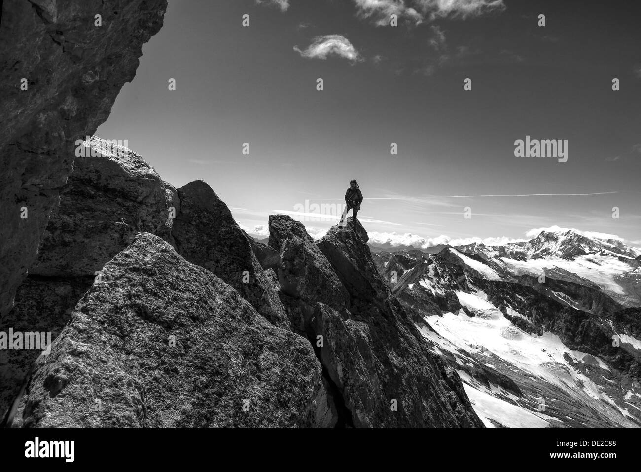 A lady on an exposed alpine ridge climb Stock Photo