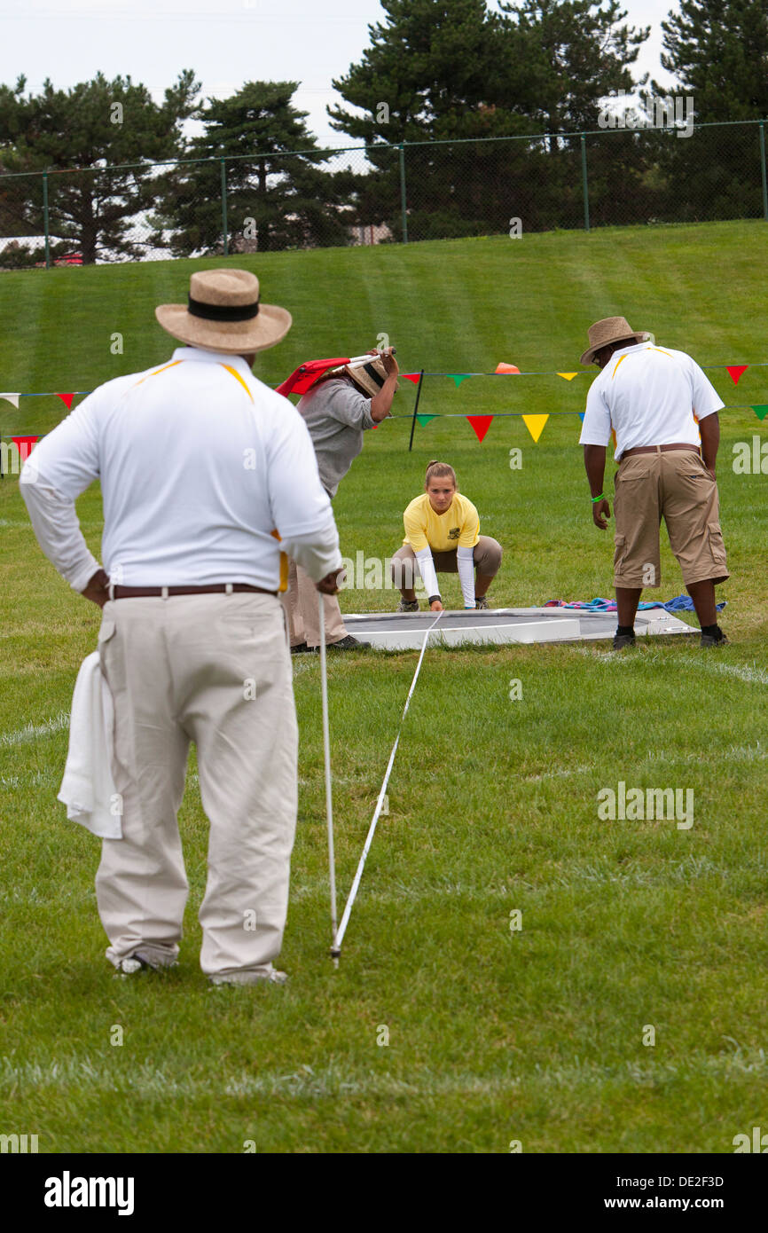 Officials measure the distance of a competitor's throw in Shot Put competition at the AAU Junior Olympic games. Stock Photo