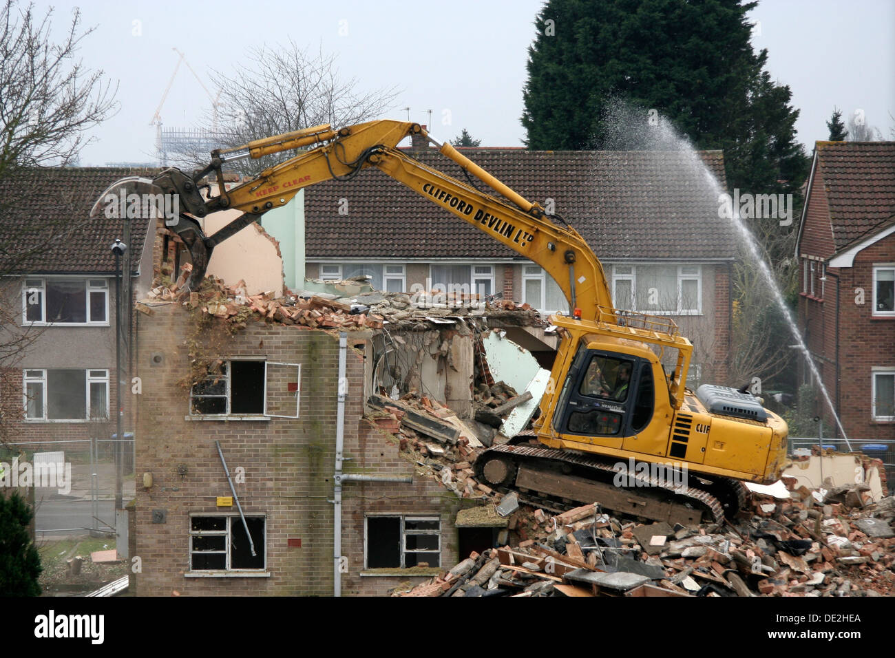 The Demolition of a Small block of Flats using an excavator. Water