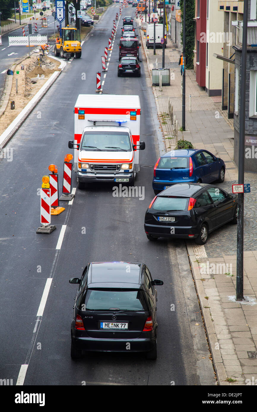 Ambulance for a trip alarm with flashing lights and sirens. Moves to an inner-city site against the direction of traffic. Stock Photo