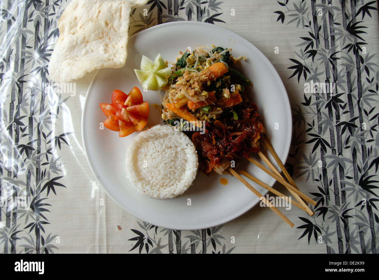 Restaurant, Indonesian food, Nasi Campur with sate sticks and rice, and Krupuk, shrimp crackers, Ubud, Bali, Indonesia Stock Photo