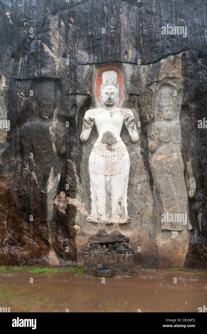 Shrine of Mahayana Buddhism, three old Buddha statues as rock reliefs, Avalokiteshvara in white, Tara on the right, Buduruvagala Stock Photo