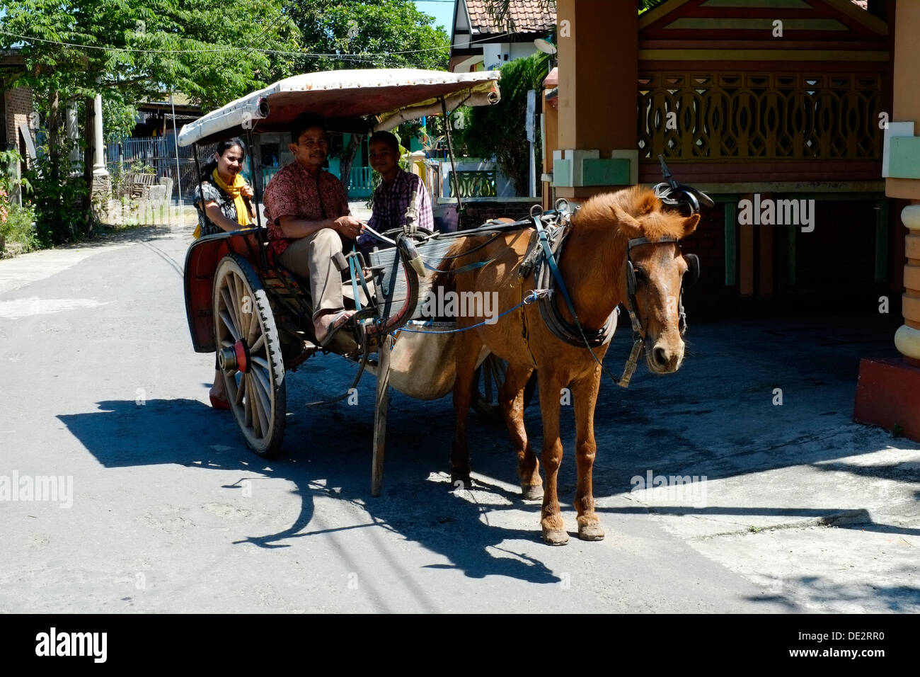 family in a horse and cart dokar a traditional inexpensive means of transport in indonesia Stock Photo