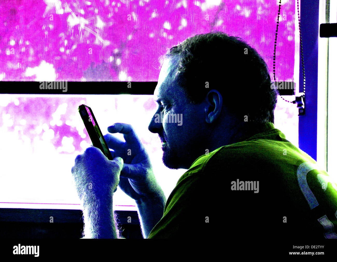 digitized portrait of adult male texting on mobile phone in front of window Stock Photo