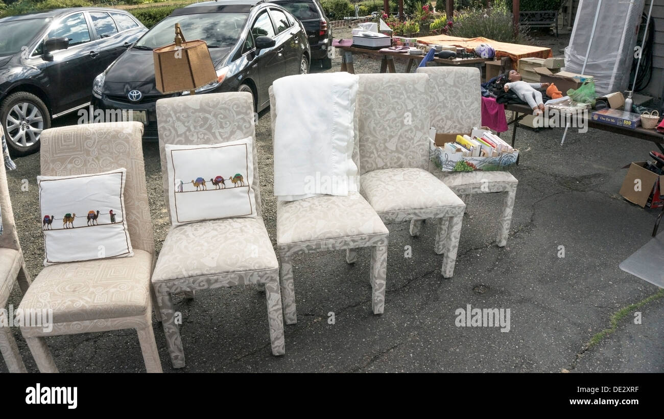 comical lineup of 6 impractically reupholstered side chairs displayed in suburban driveway at garage sale Edmonds Washington Stock Photo