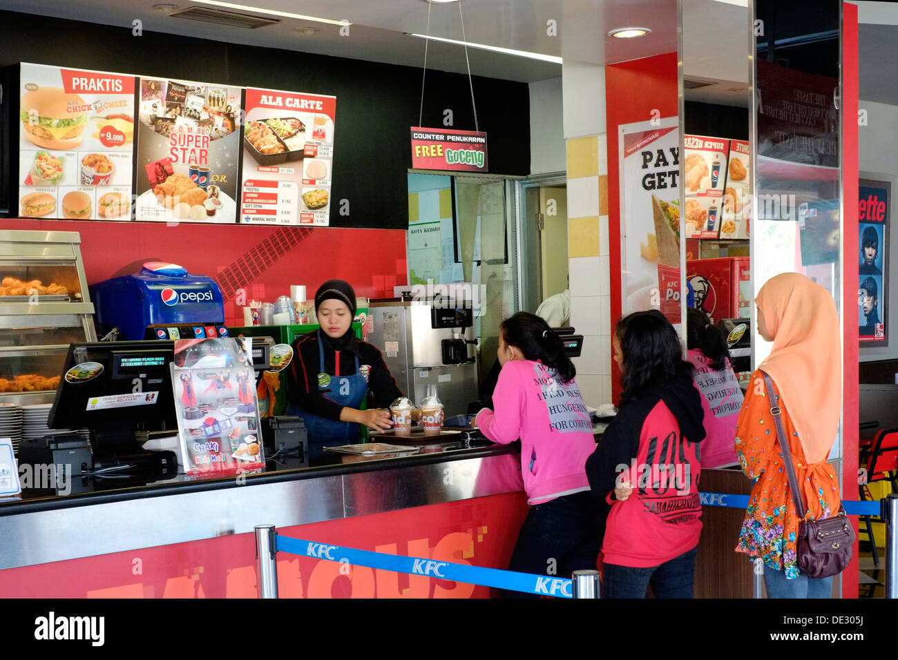 customers queue for fast food in a kentucky fried chicken branch in kediri java indonesia Stock Photo