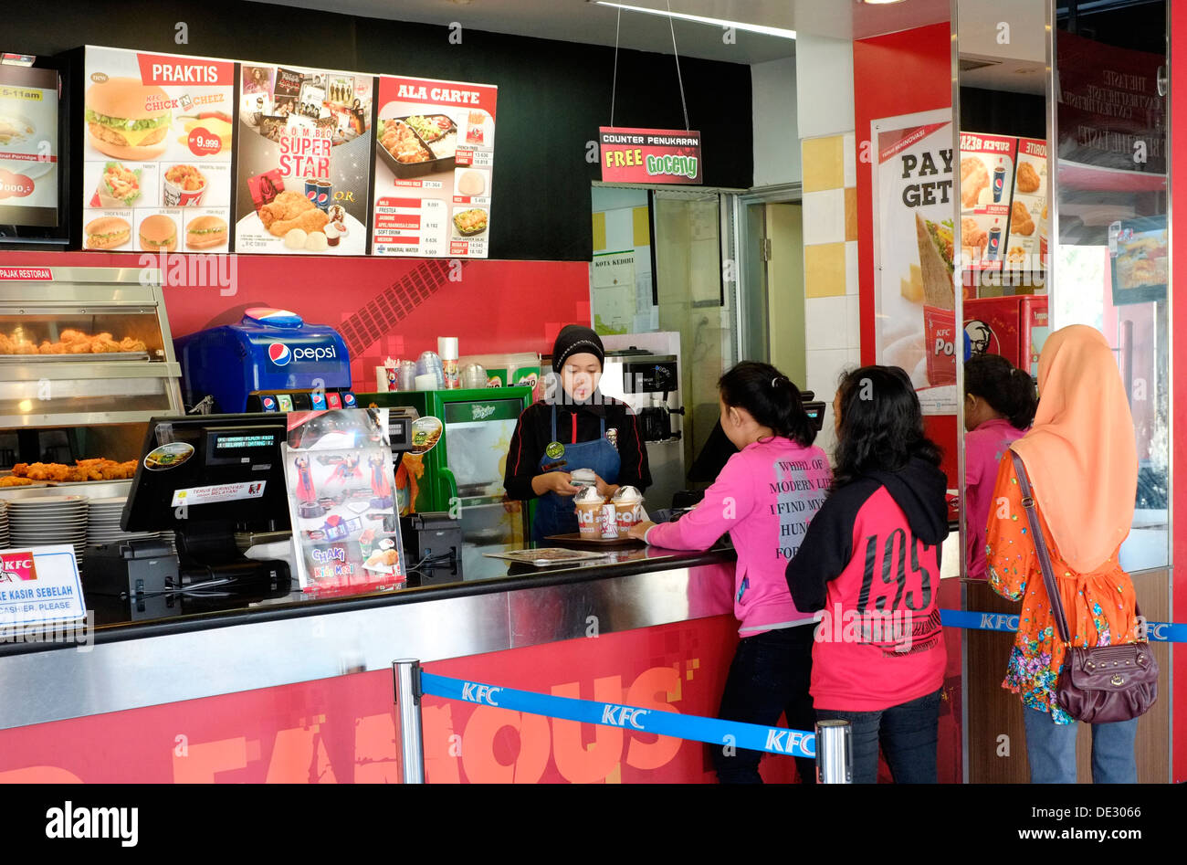 customers queue for fast food in a kentucky fried chicken branch in kediri java indonesia Stock Photo