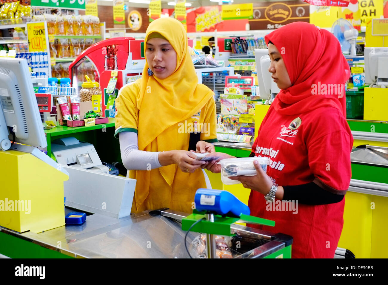 two female cashiers at the checkout in a supermarket Stock Photo