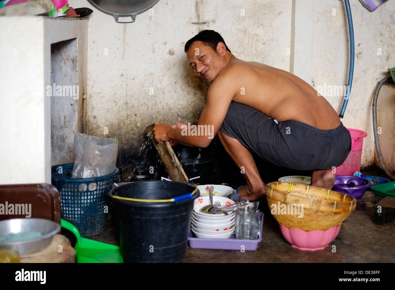 https://c8.alamy.com/comp/DE38FF/smiling-local-man-washing-dishes-in-the-kitchen-of-his-warung-malang-DE38FF.jpg