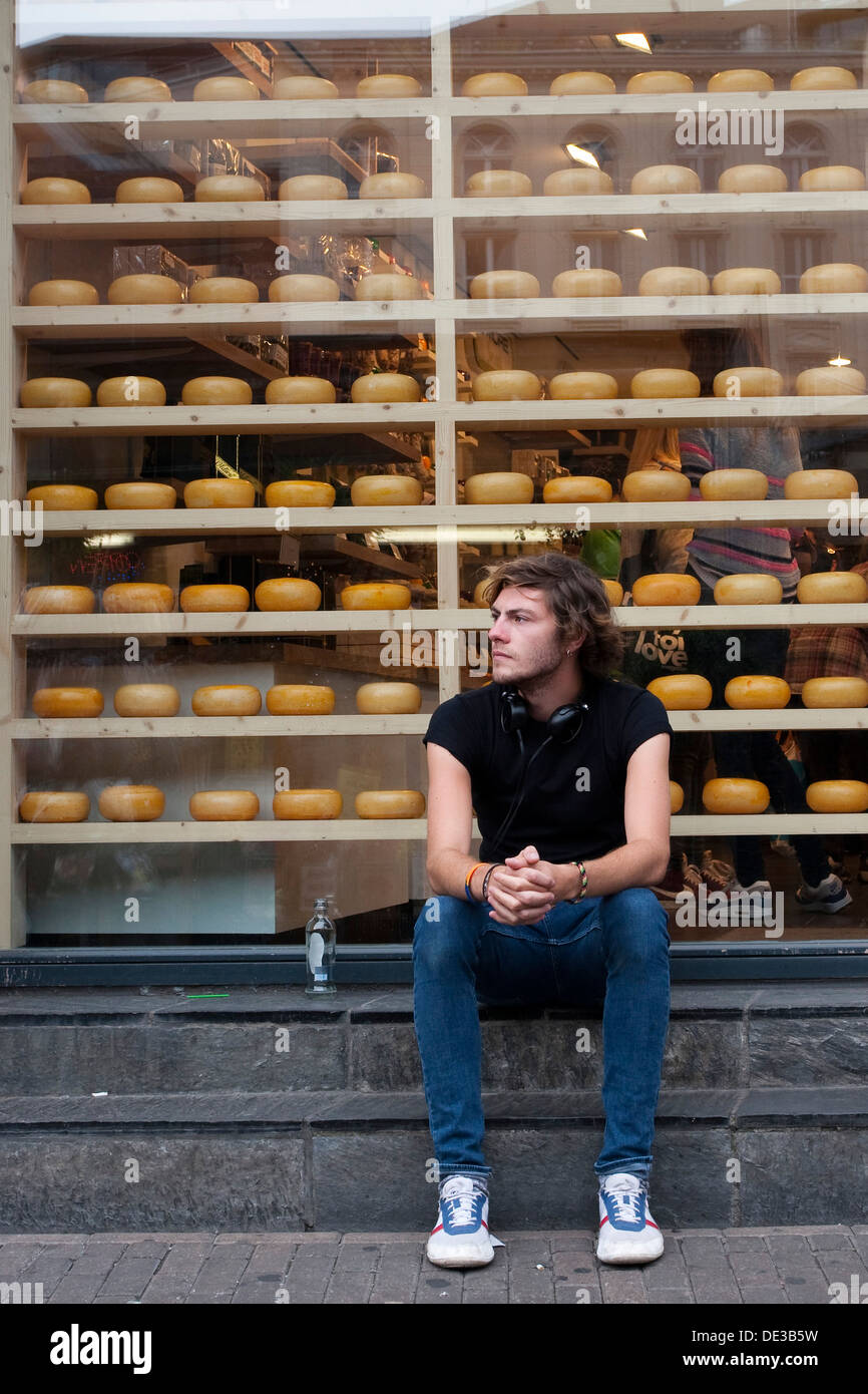 A man sitting outside a shop selling dutch cheese. Stock Photo