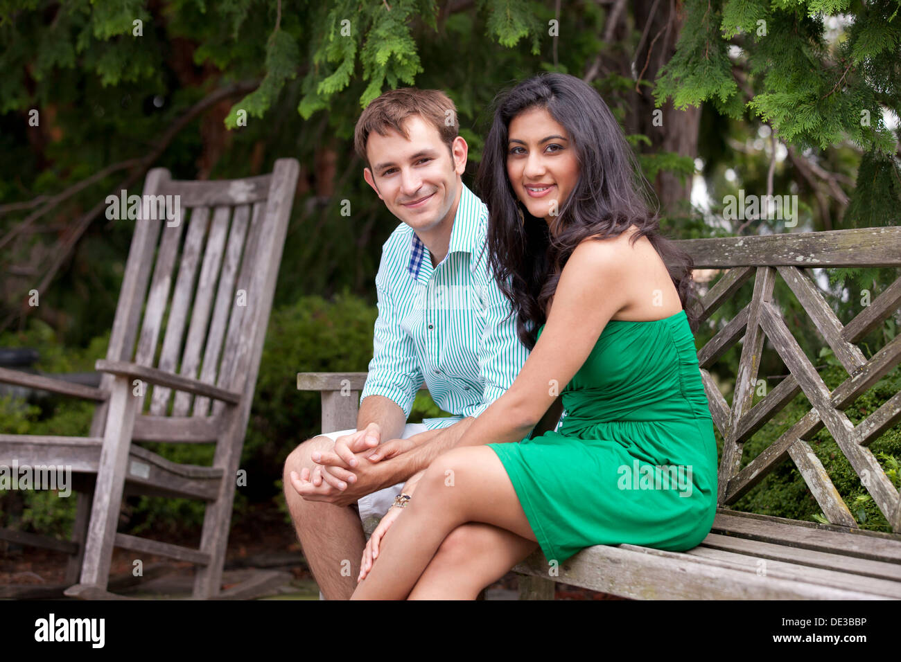Young Caucasian couple sitting on park bench Stock Photo