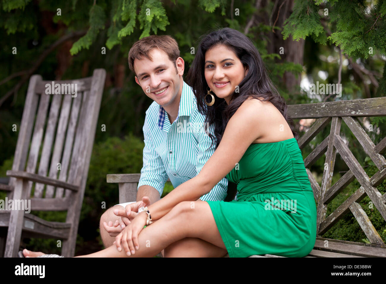 Young Caucasian couple sitting on park bench Stock Photo