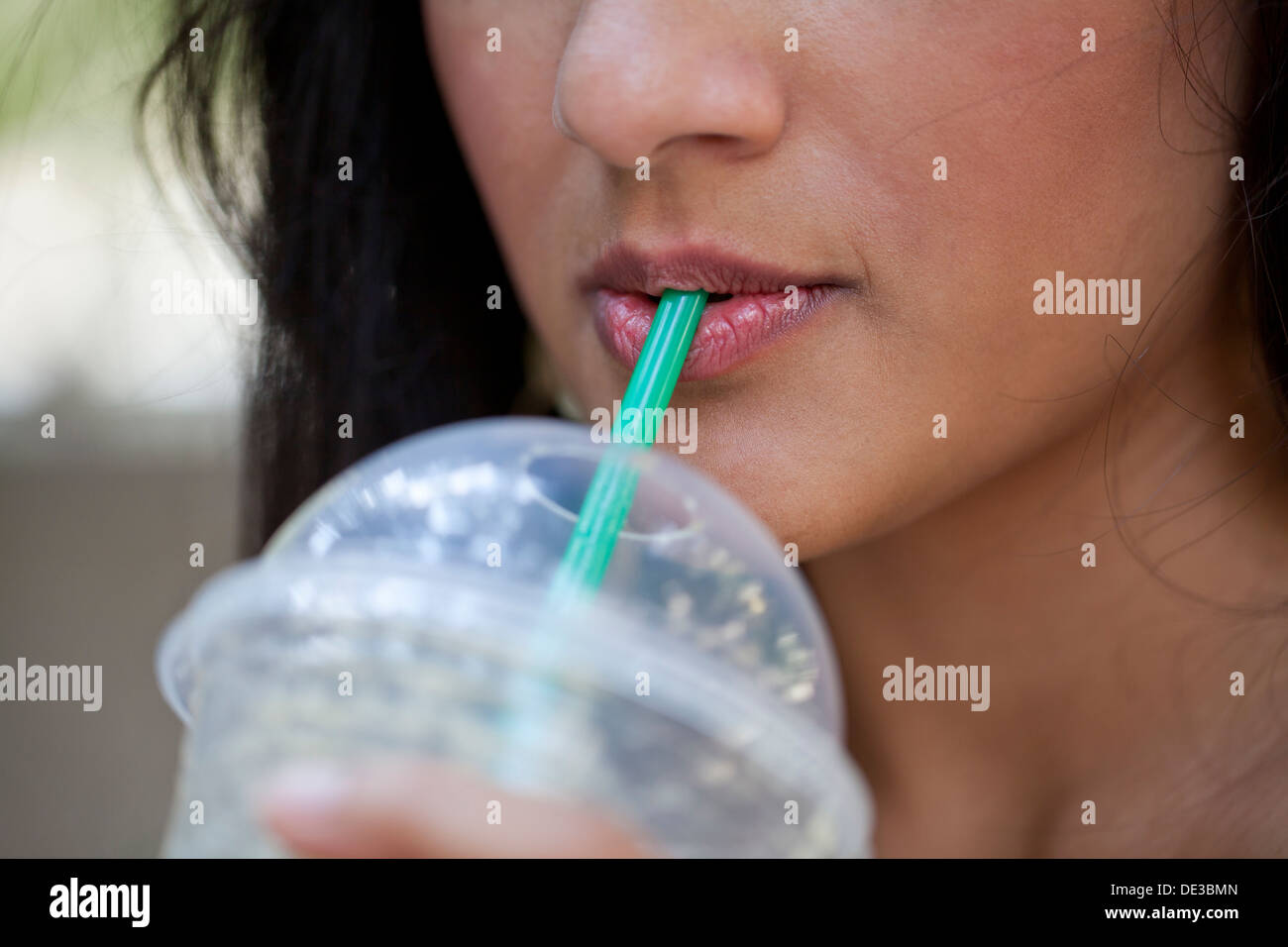 Closeup of woman drinking an iced coffee Stock Photo