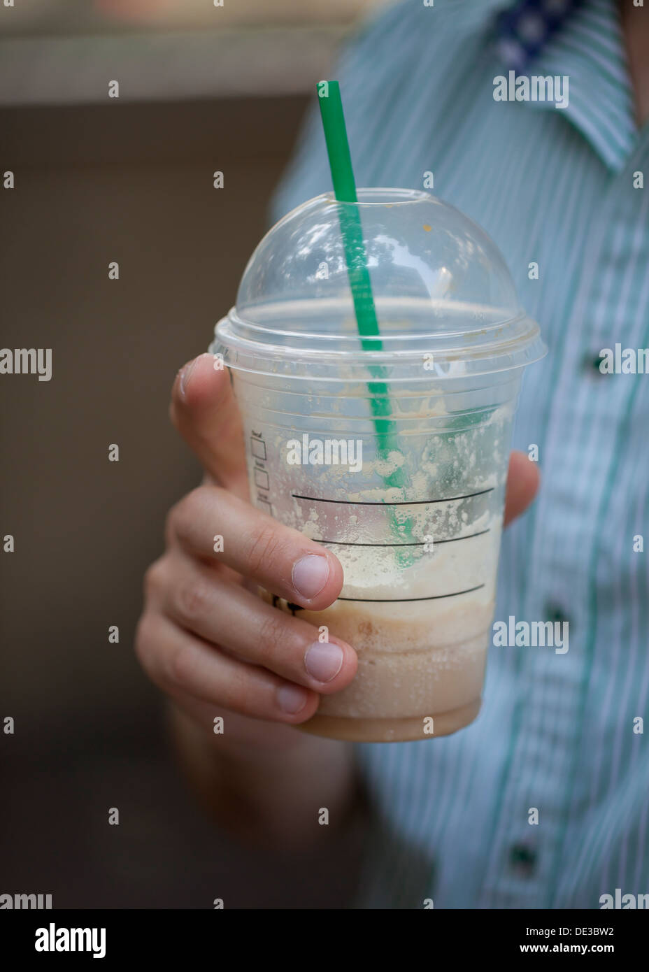Man holding an iced coffee drink in hand Stock Photo