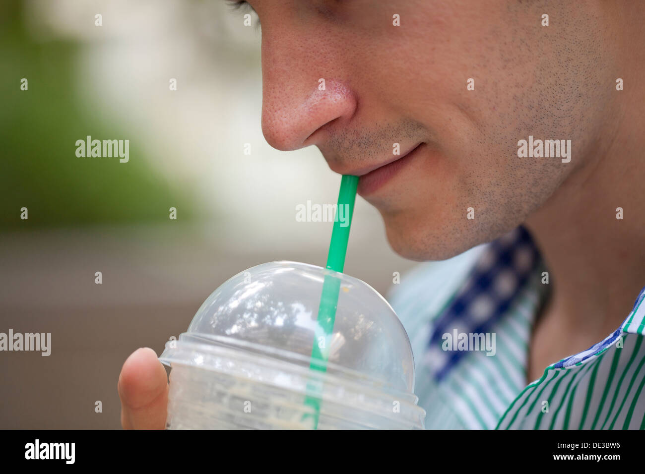 Man drinking an iced coffee Stock Photo