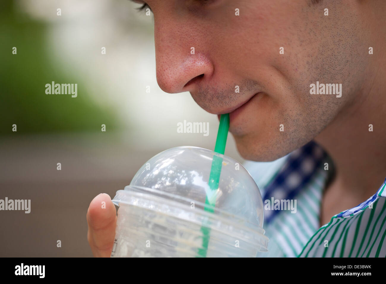Man drinking an iced coffee Stock Photo